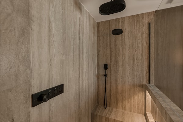Modern walk-in shower with stone walls and rainfall showerhead